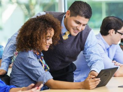 volunteer teaching high school student at a laptop computer